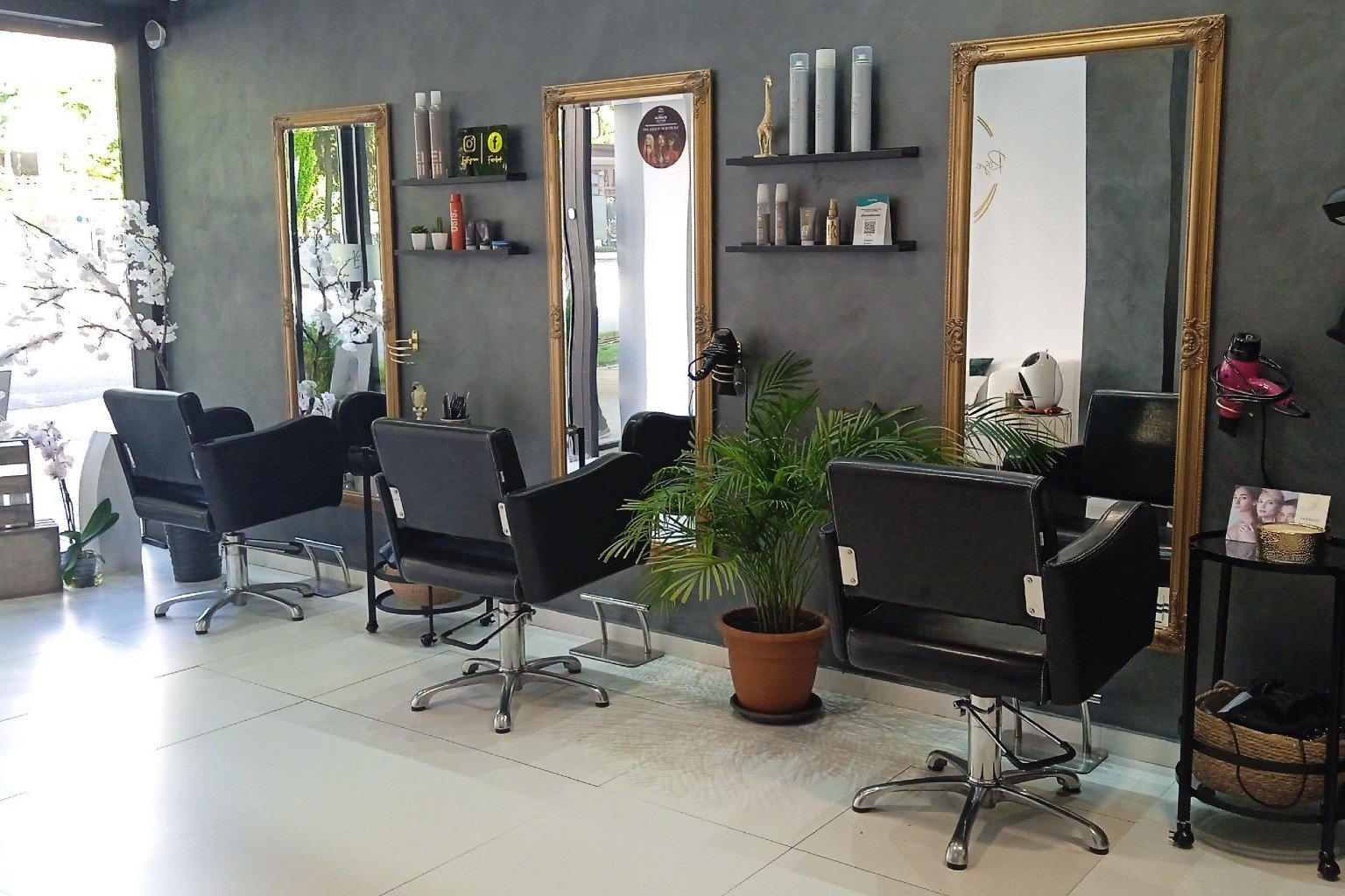Puestos de peluquería con espejos dorados en Rose's Beauty